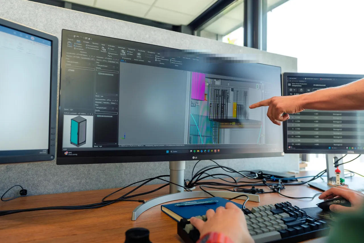 Engineers bespreken het 3D-model van een besturingskast tijdens de digitale review