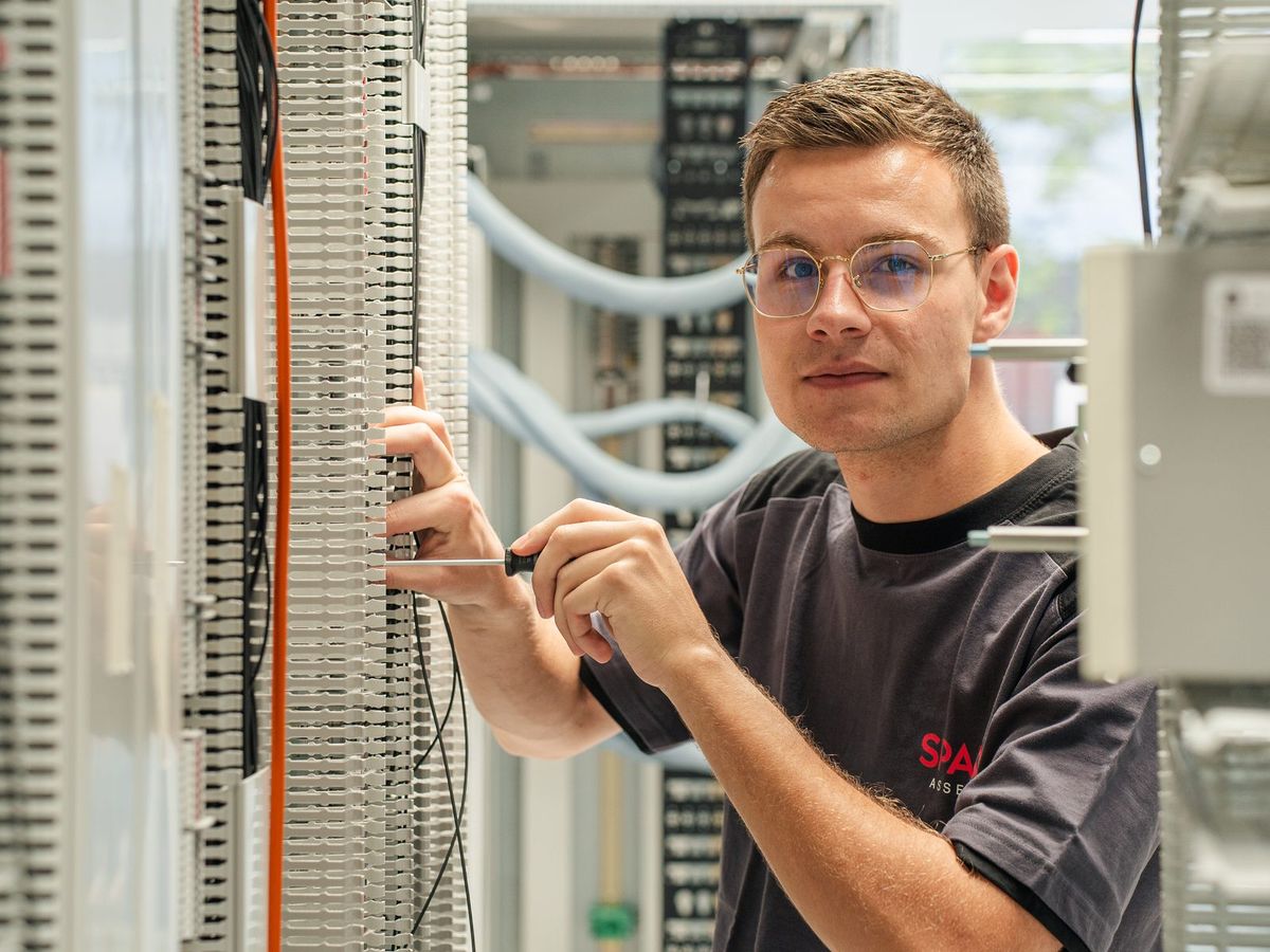 Jonge SPARQ-monteur bedraadt de klemmenstroken van een besturingskast