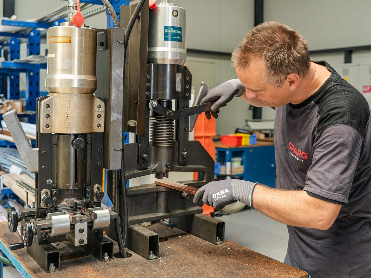Monteur van SPARQ bewerkt koperen rails voor een laagspanningsverdeler